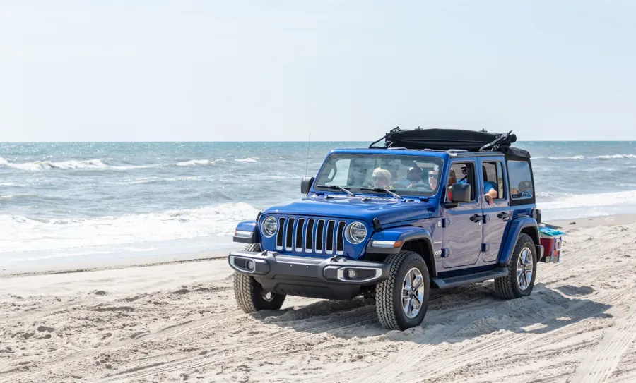 Jeep azul en la playa, con el mar de Los Cabos de fondo