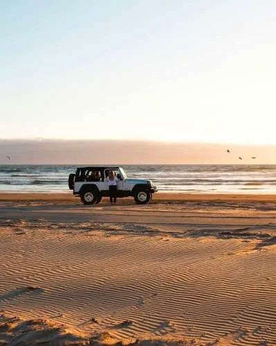 Jeep blanco al atardecer en la playa